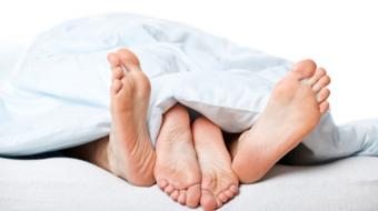 couples feet underblanket bed